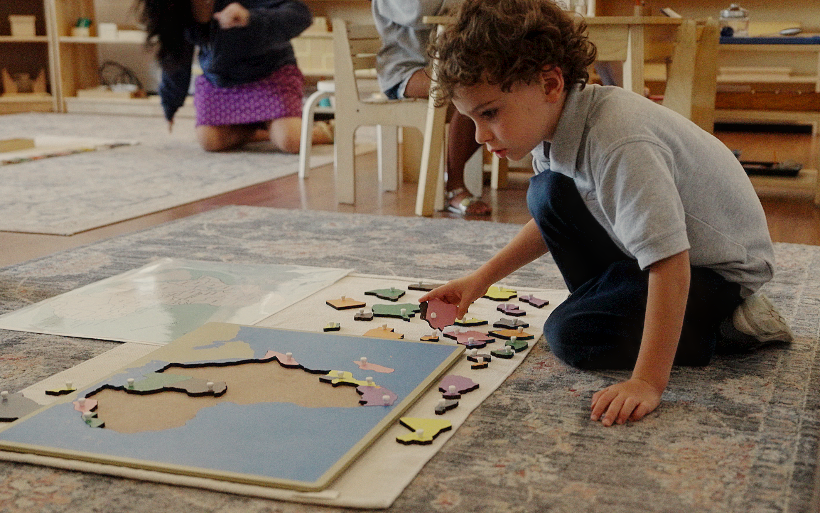 Student working on a map puzzle at their desk