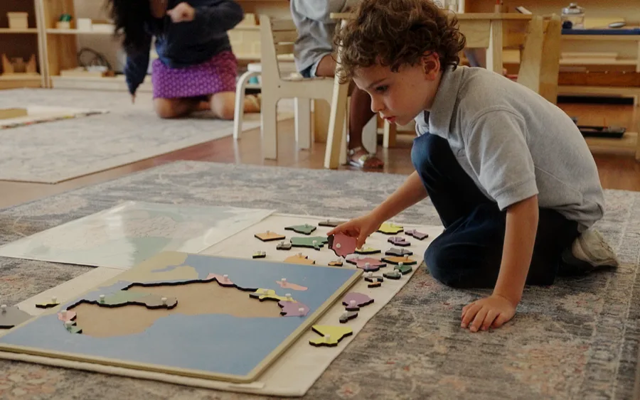 Student working on a map puzzle at their desk
